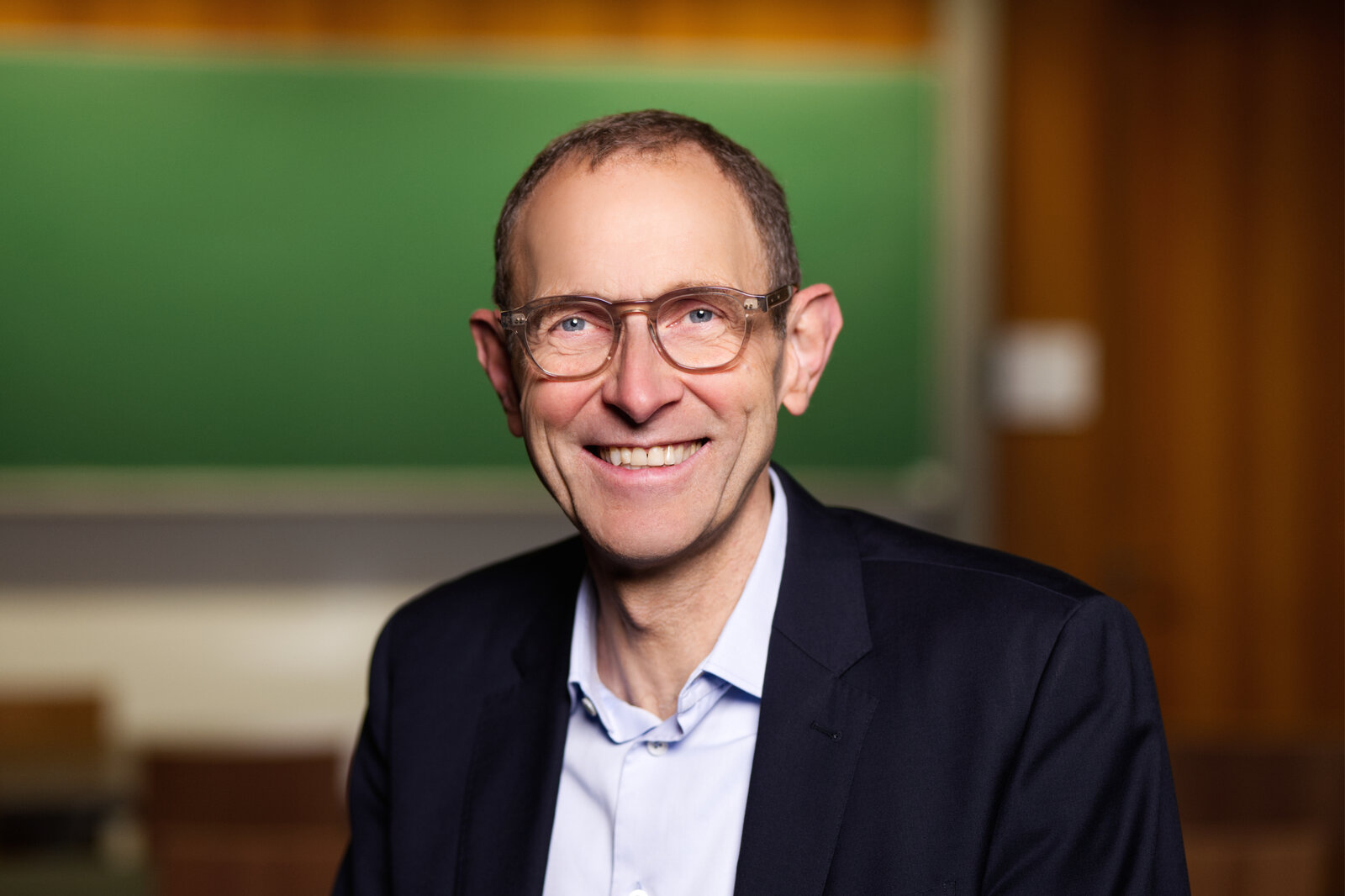 Mann mit Brille lächelt.