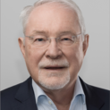 Ein Mann mit randloser Brille schaut freundlich in die Kamera.