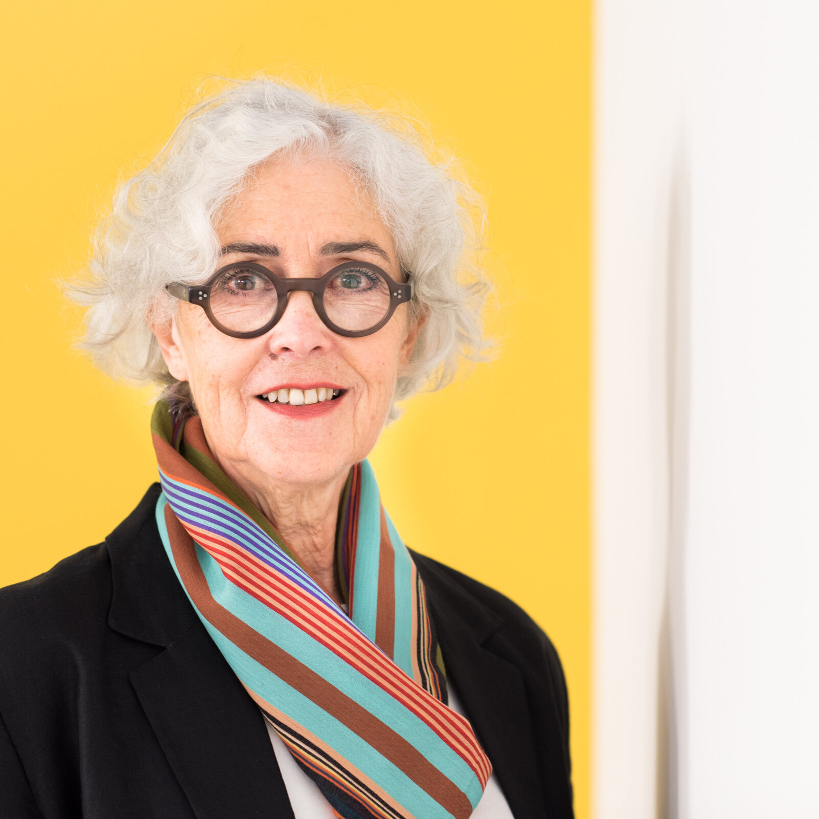 Eine Frau mit Brille lächelt in die Kamera.