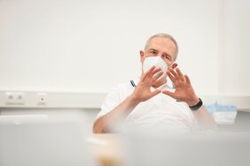 Professor Dr. Bernd K. Fleischmann mit FFP2-Maske im Gespräch