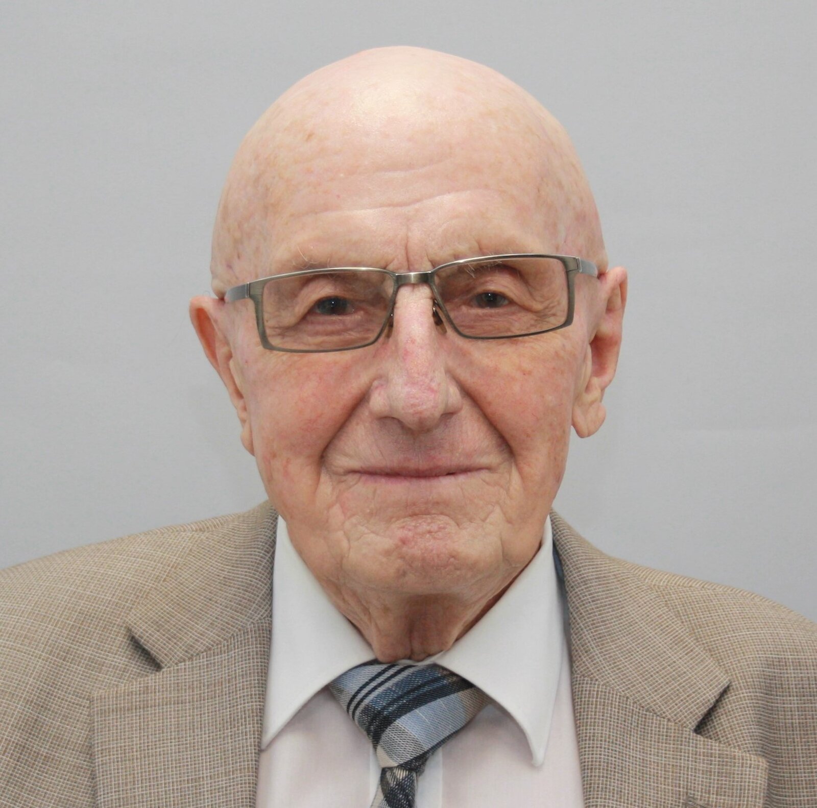 Ein Mann mit Brille schaut freundlich in die Kamera.