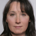 Frau mit langen Haaren schaut freundlich in die Kamera.