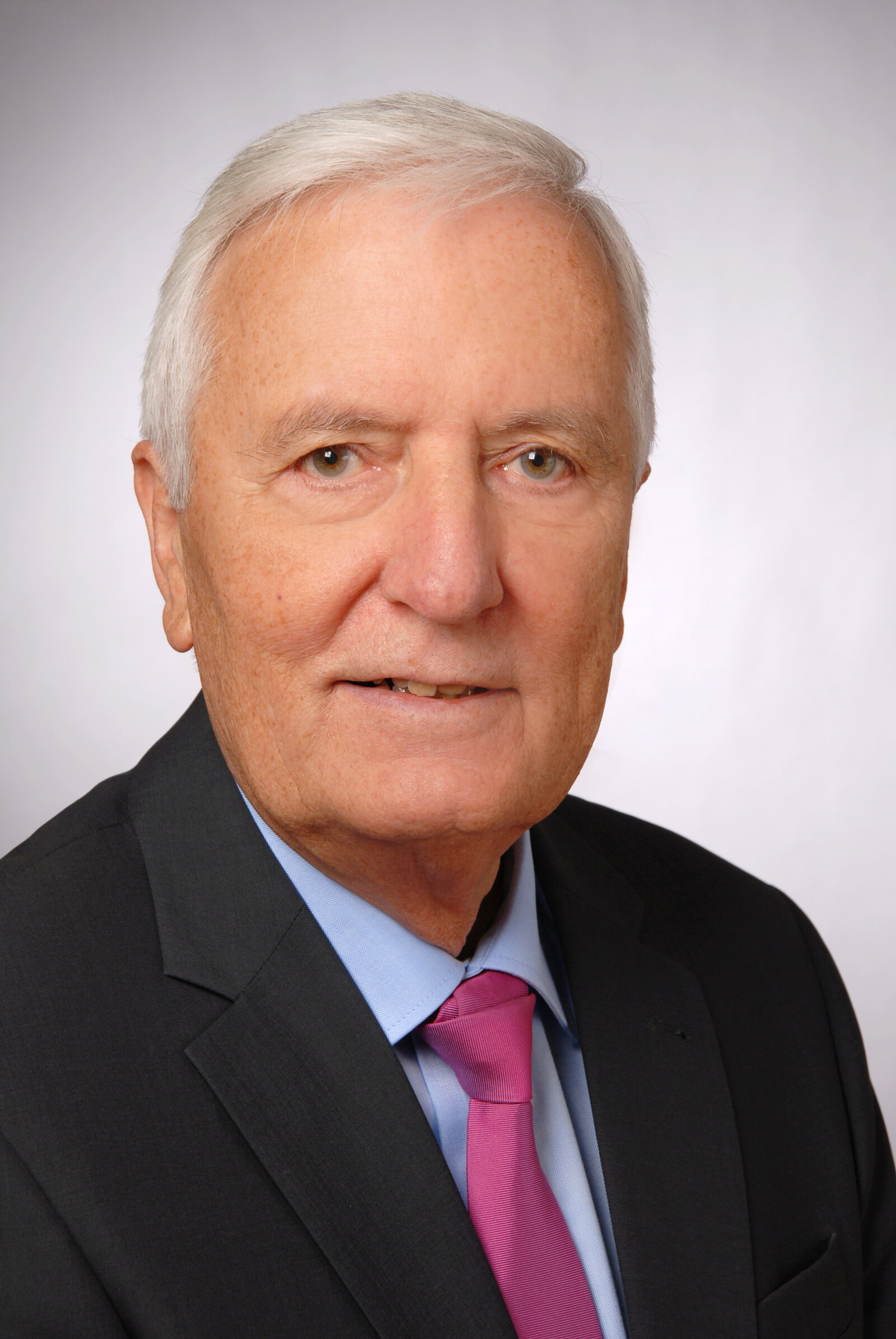 Ein Mann schaut lächelnd in die Kamera.