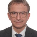 Mann mit Brille lächelt in die Kamera.