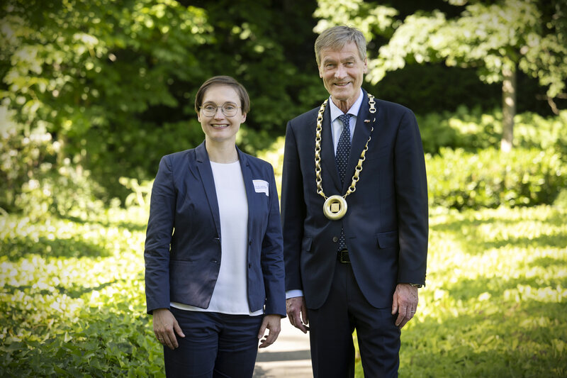 Eine Frau und ein Mann haben sich in einem Park für ein Foto aufgestellt.