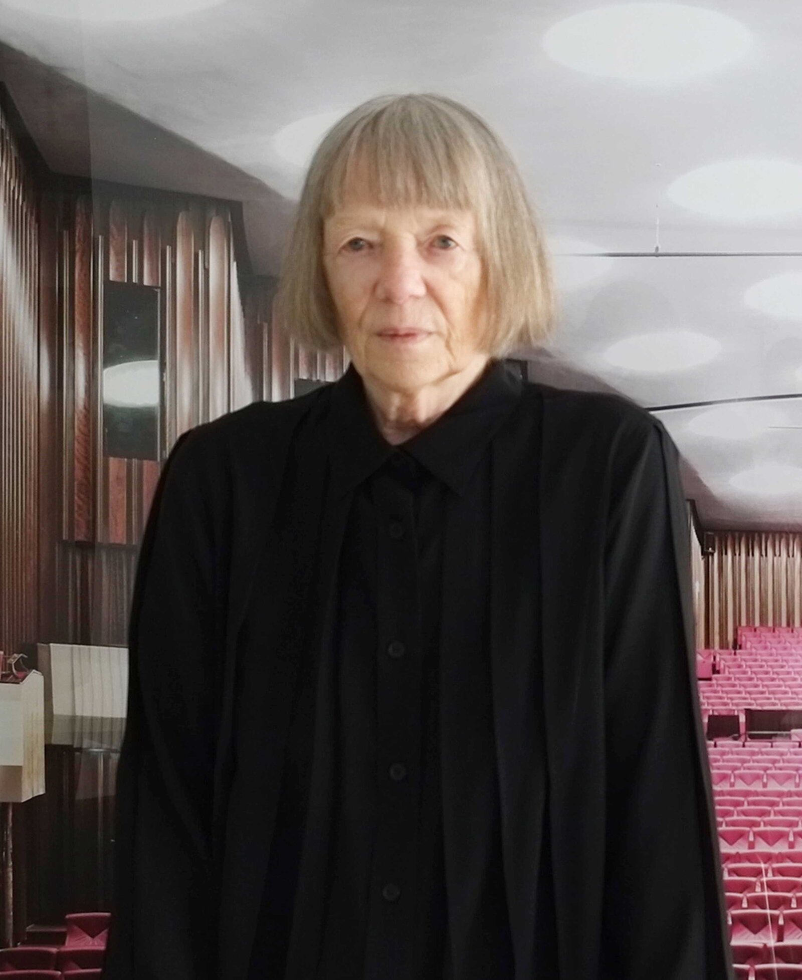 Eine Frau steht im Zuschauerraum eines Theaters.