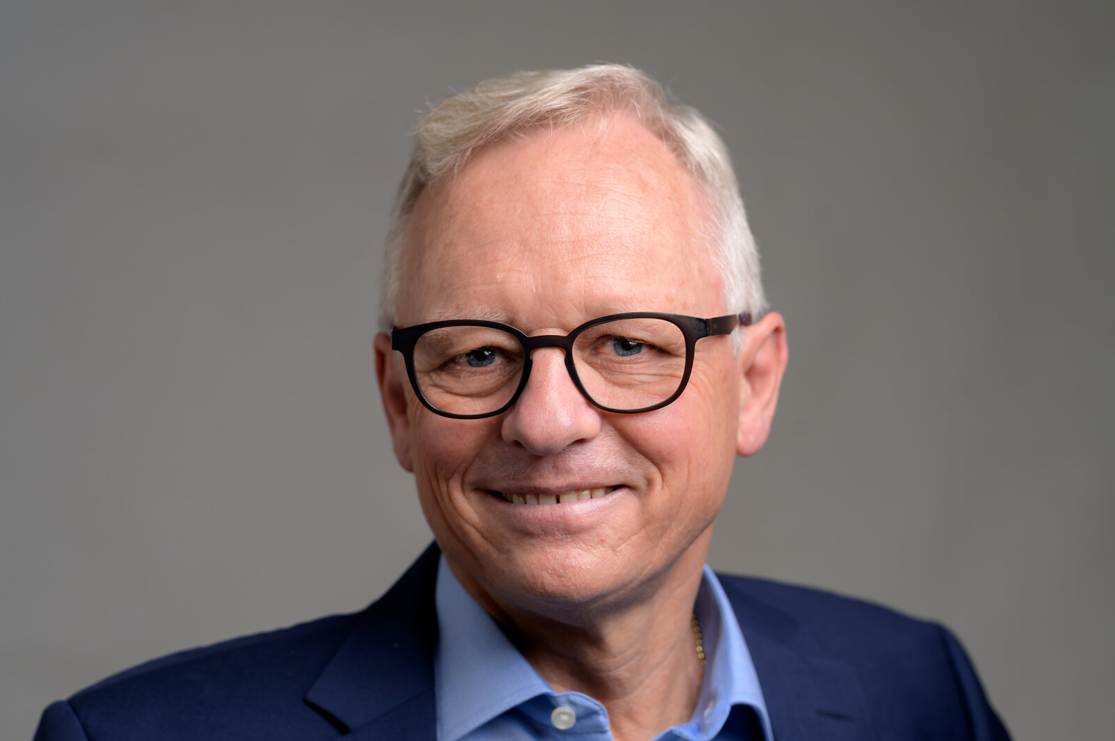 Ein Mann mit Brille lächelt in die Kamera.