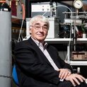 Ein Mann mit Brille sitzt vor technischen Geräten. Er schaut freundlich in die Kamera.