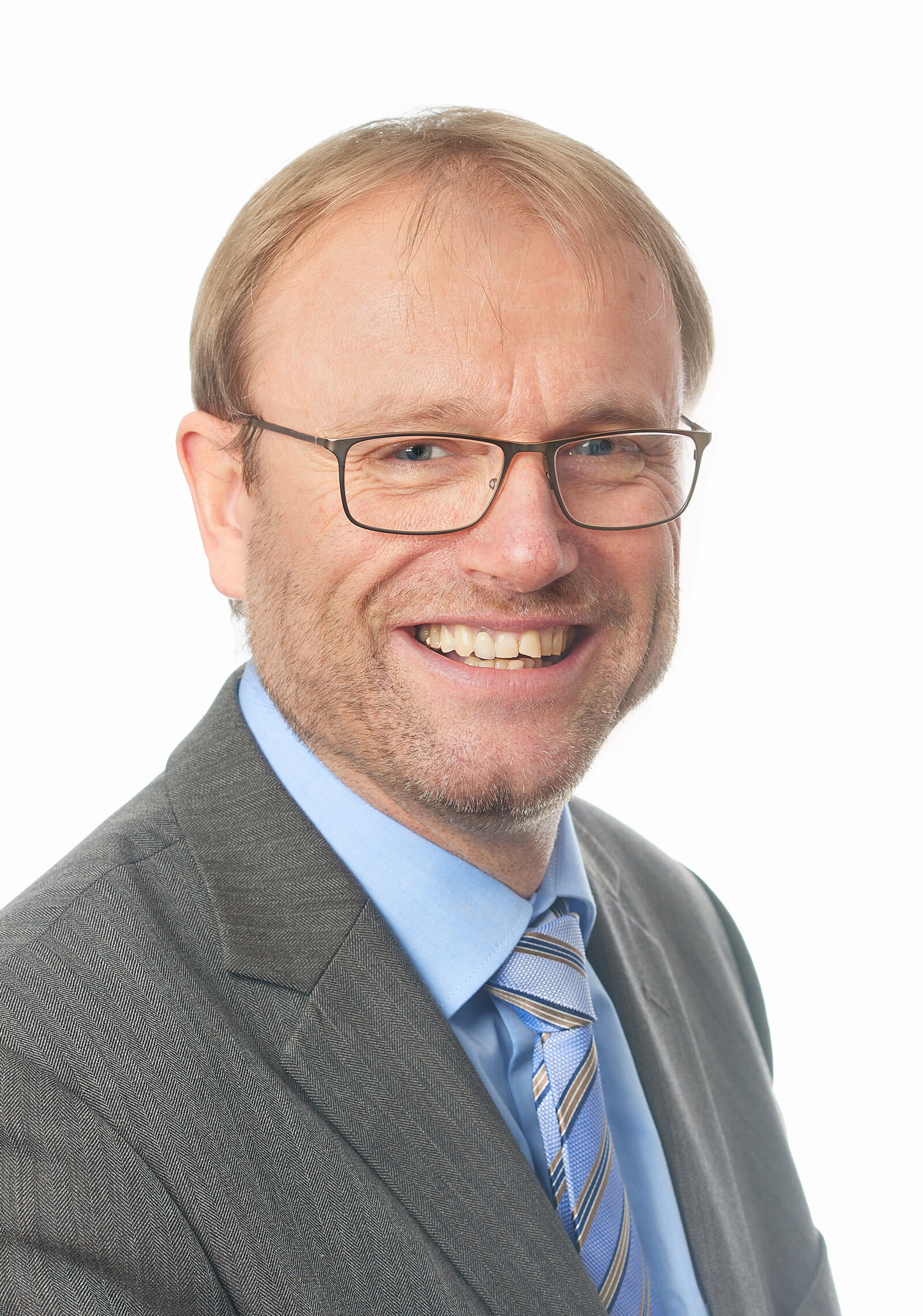 Ein Mann mit Brille lächelt strahlend.