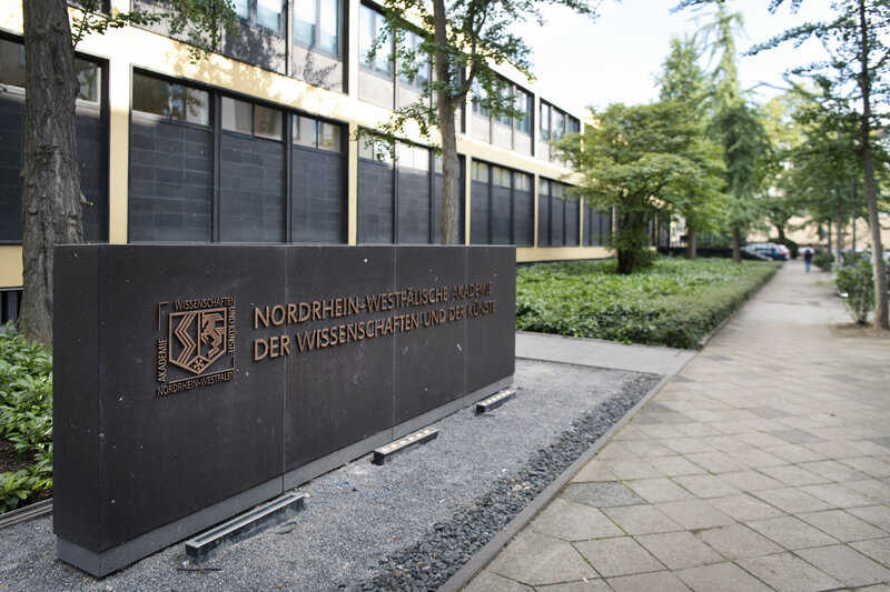 Tafel mit Aufschrift "Nordrhein-Westfälische Akademie der Wissenschaften und der Künste" vor dem Gebäude