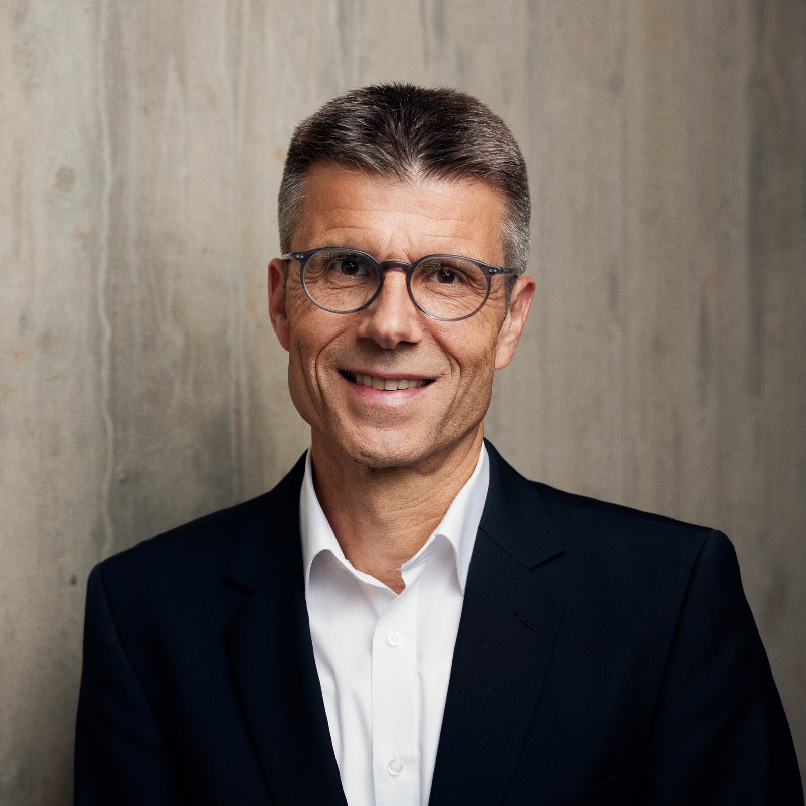 Ein Mann mit Brille lächelt in die Kamera.