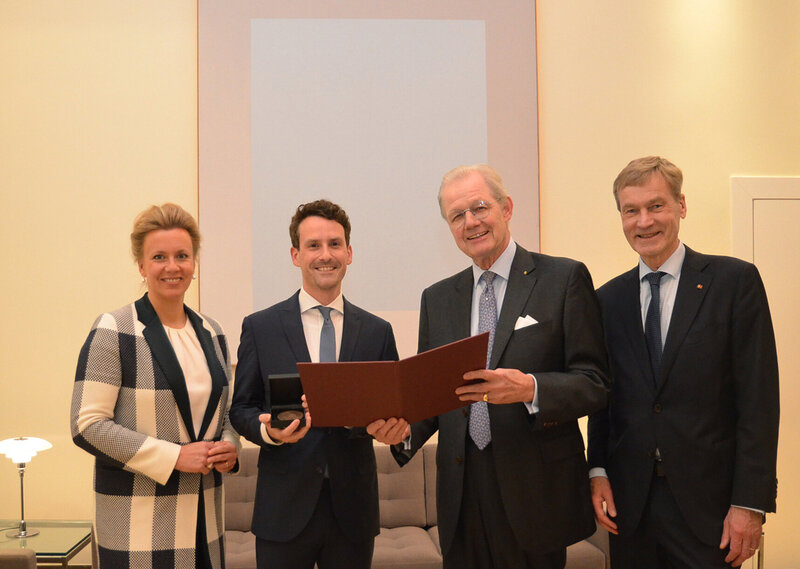 Drei Männer und eine Frau haben sich für ein Foto aufgestellt. 