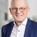 Ein Mann mit Brille lächelt in die Kamera.