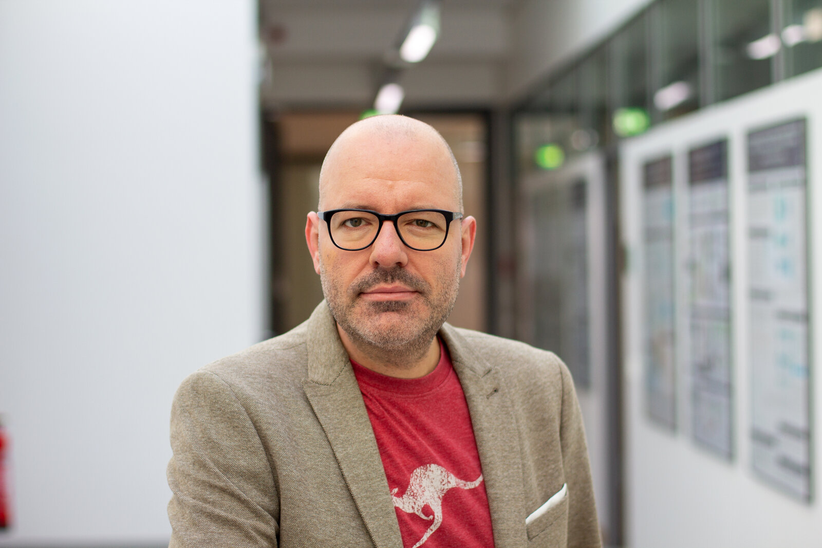 Ein Mann mit Brille schaut freundlich in die Kamera.