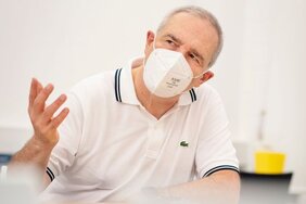 Professor Dr. Bernd K. Fleischmann mit FFP2-Maske im Gespräch