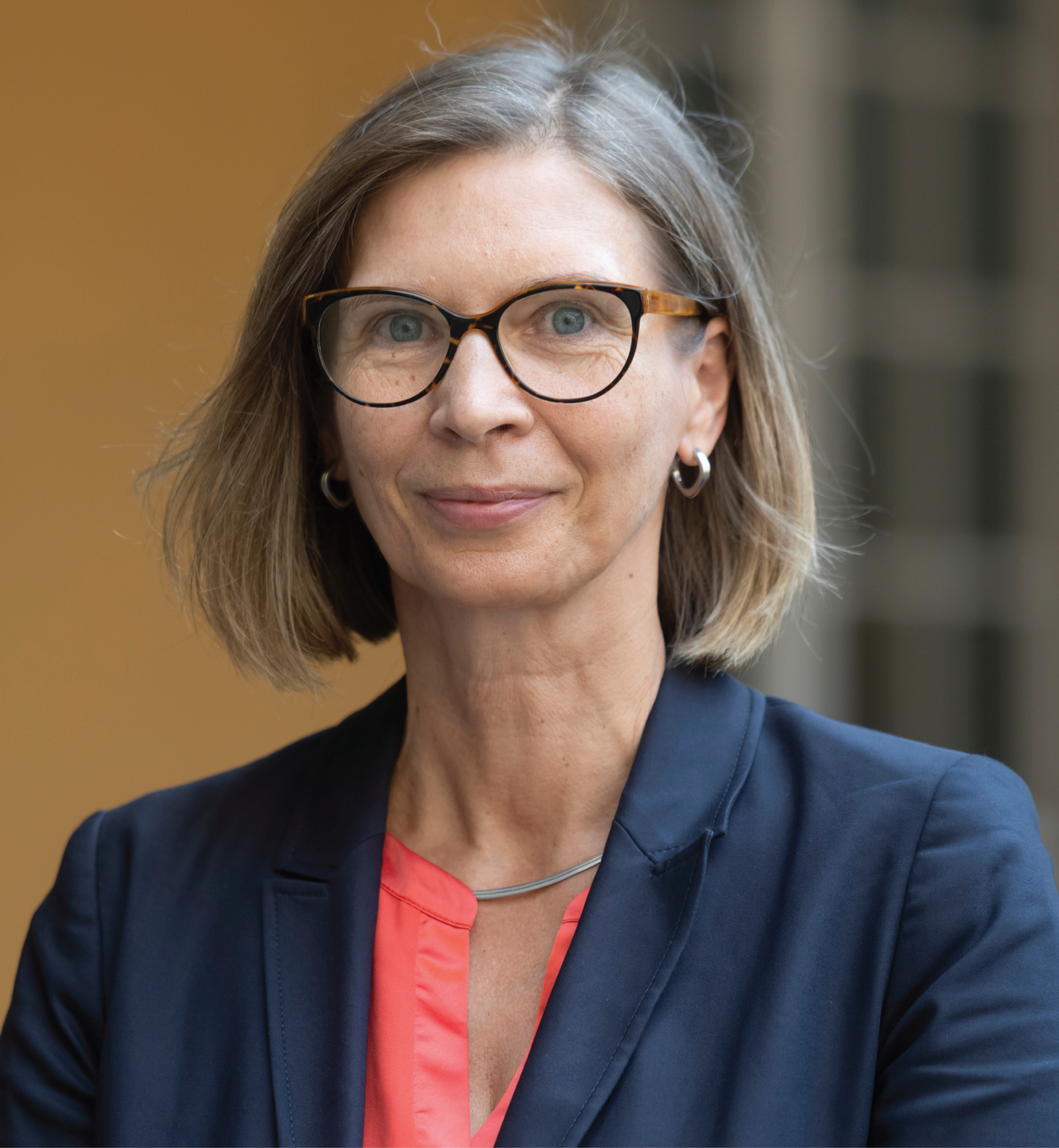 Eine Frau mit Brille und halblangen Haaren lächelt in die Kamera.