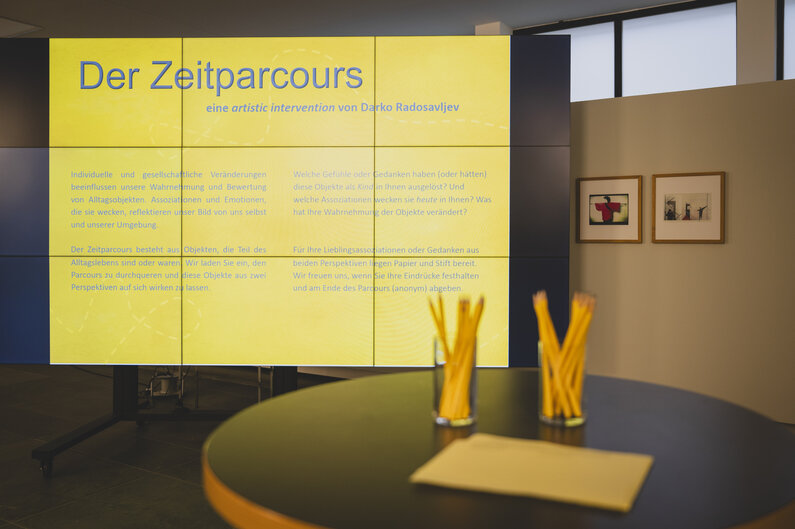 Auf einer Leuchttafel steht auf gelbem Hintergrund "Der Zeitparcours".