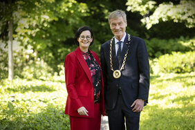 Ein Mann und eine Frau haben sich in einem Park für ein Foto aufgestellt.