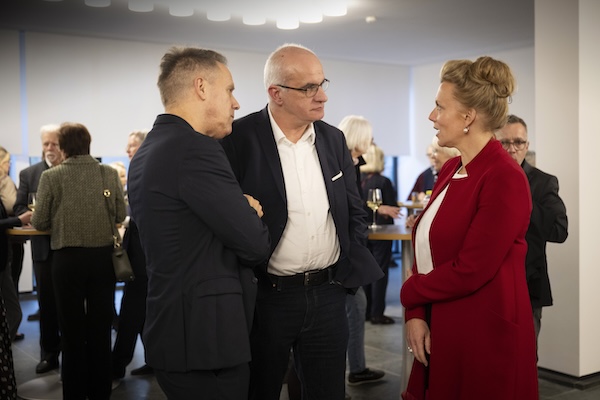 Menschen unterhalten sich im Foyer der Akademie. 
