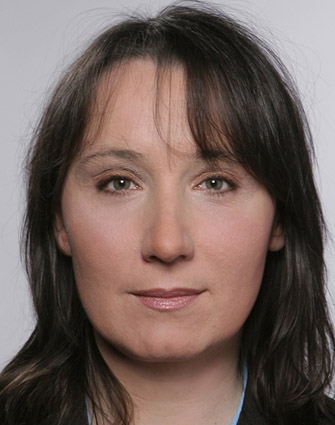 Frau mit langen Haaren schaut freundlich in die Kamera.