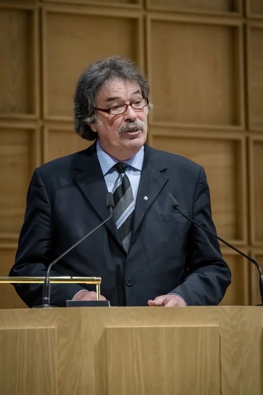 Ein Mann mit Brille hält einen Vortrag.