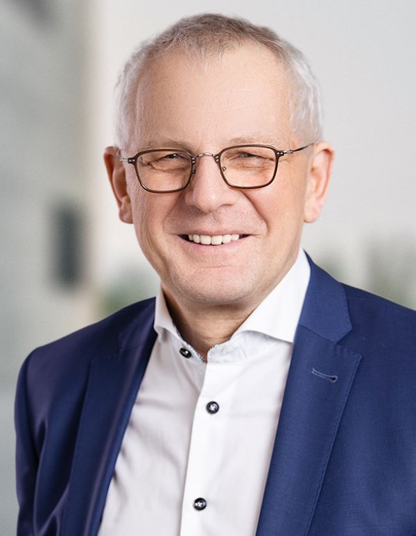 Ein Mann mit Brille lächelt in die Kamera.
