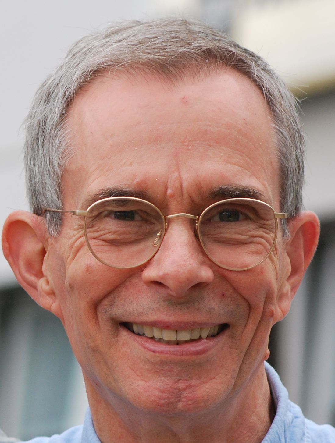 Ein Mann mit Brille lächelt in die Kamera.