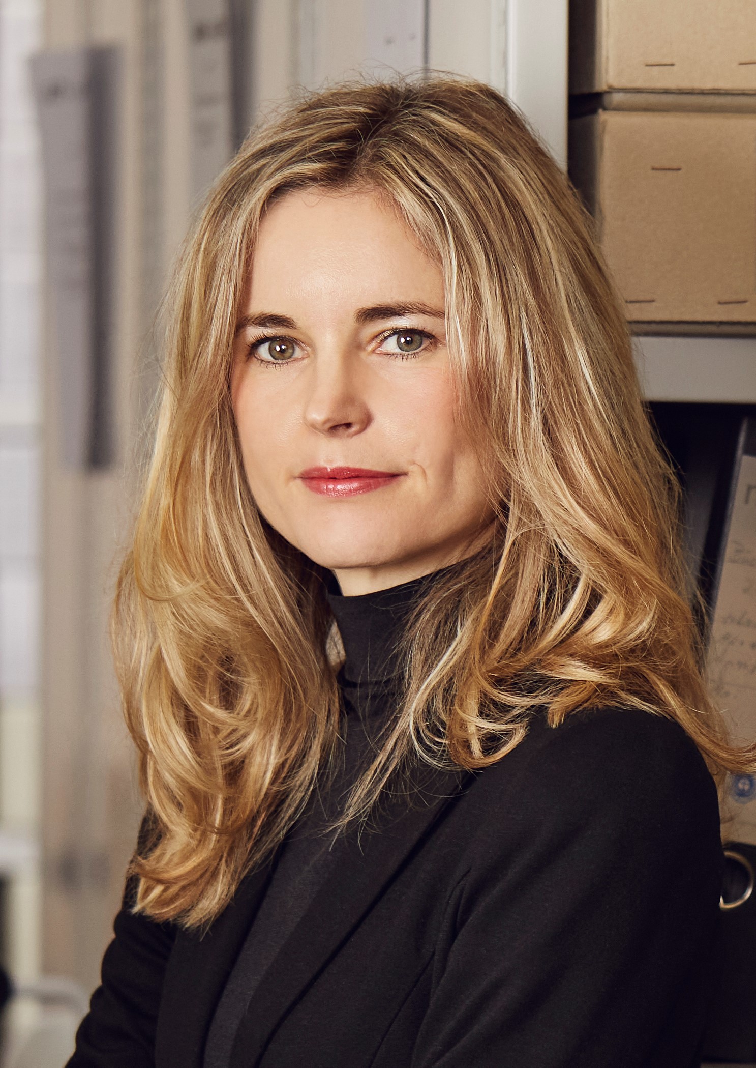 Eine Frau schaut freundlich in die Kamera.