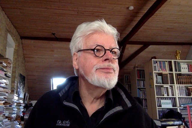 Ein Mann mit Brille und Bart schaut nach rechts.