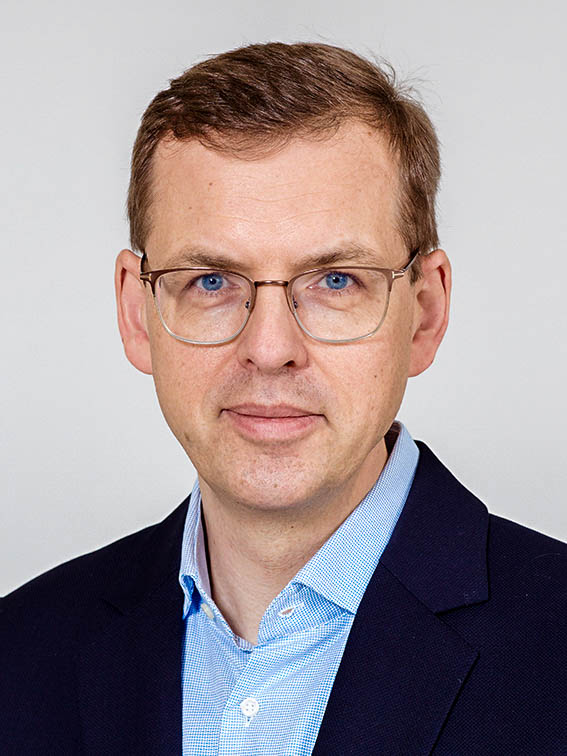 Mann mit Brille schaut freundlich in die Kamera.