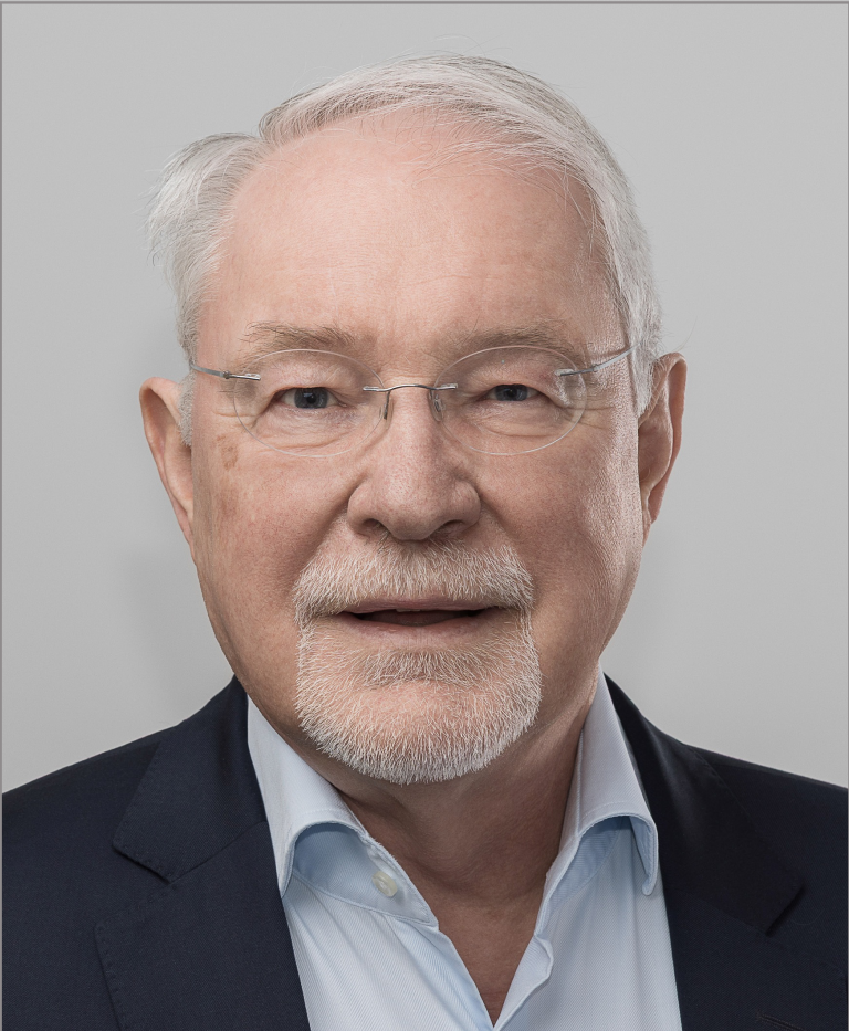Ein Mann mit randloser Brille schaut freundlich in die Kamera.