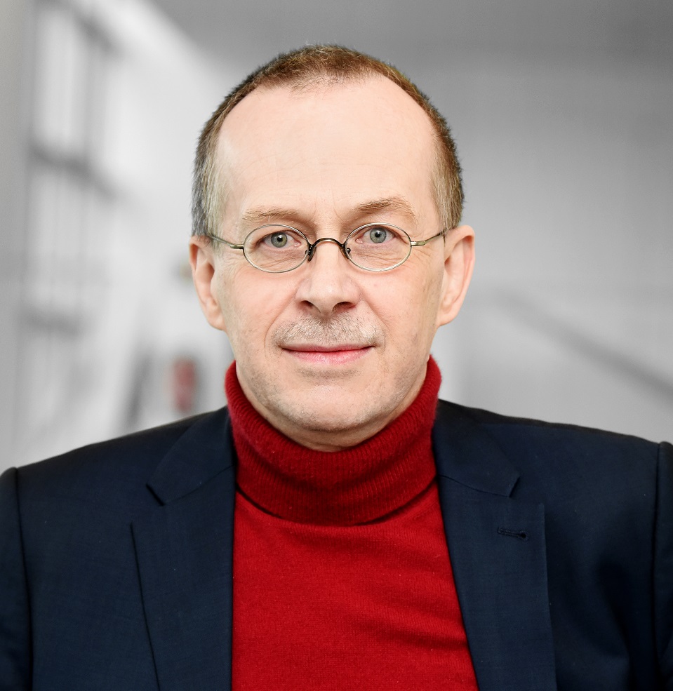 Ein Mann mit Brille schaut freundlich in die Kamera.
