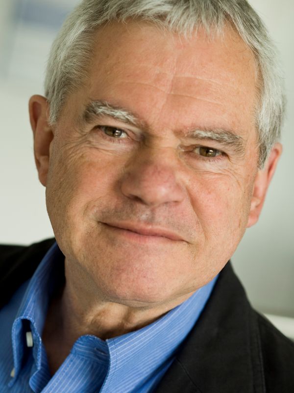 Ein Mann schaut freundlich lächelnd in die Kamera.