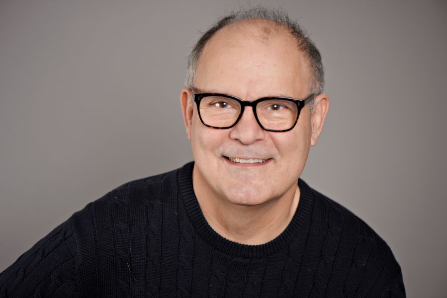 Ein Mann mit Brille lächelt in die Kamera.